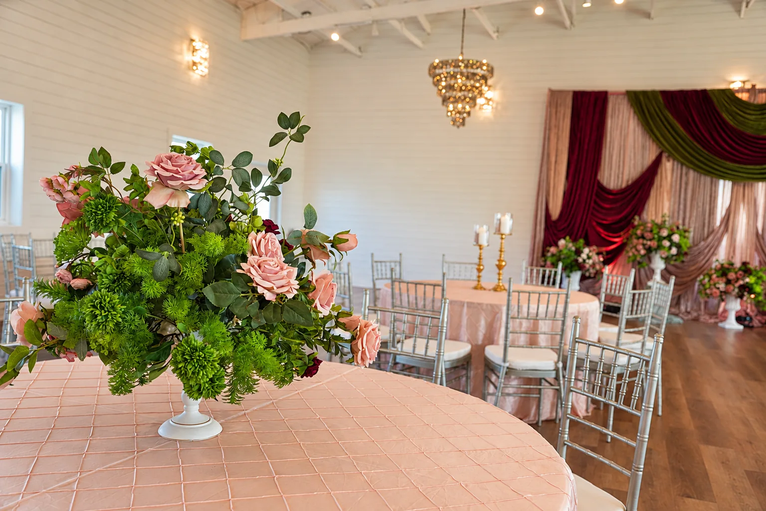 Floral table setting beneath chandeliers in the ranch ballroom