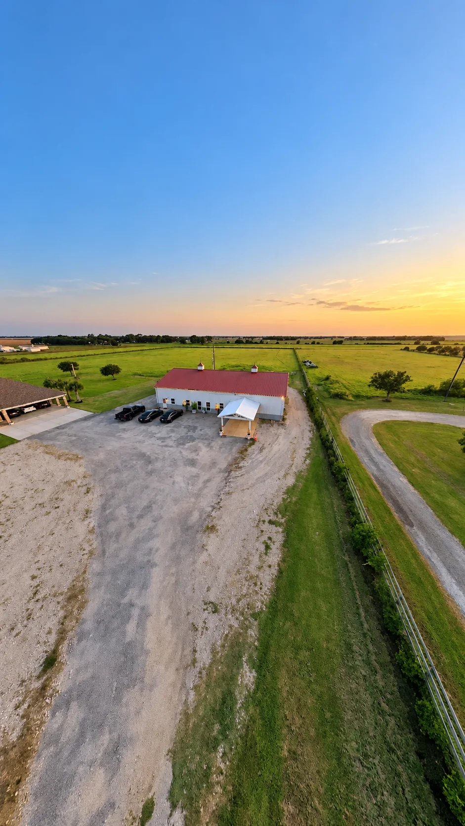 Drone view of Texas AZ Paradise Ranch and its driveway in Richmond, Texas, at sunset.